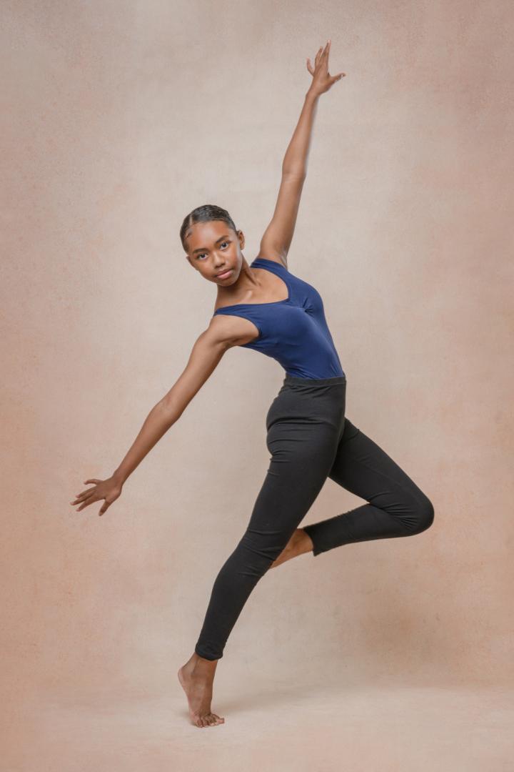 A ballet student in a dynamic pose, demonstrating expressive dance moves.